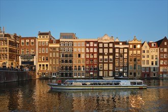 AMSTERDAM, NETHERLANDS, MAY 20, 2018: Canal cruise tourist boat in Amsterdam at Damrak canal and