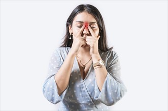 Girl with nasal bridge headache. Sinus pain concept. Young woman with pain touching nose. Person