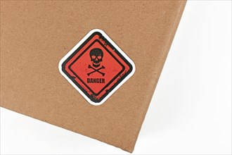 Red warning label with skull and word 'Danger' on parcel