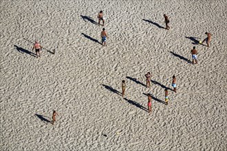 Beach volleyball on the beach of Nazaré, players cast long shadows, view from above, Portugal,