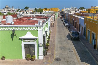 Raised view of street with cars parked and colourful Spanish colonial buildings, Campeche city