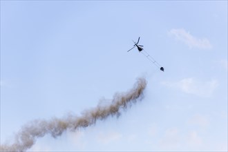 Symbolic image, climate change, helicopter, helicopter spreading finely painted limestone and ash