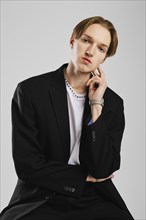 Studio shot of young thoughtful man in a black suit