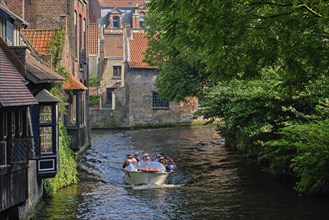 BRUGES, BELGIUM: Tourist boat with tourists in canal between old houses. Brugge Bruges, Belgium,