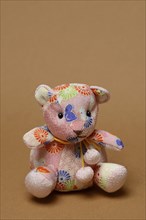 Teddy, teddy bear from Japan, in front of a brown background