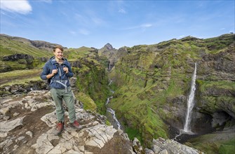 Hikers at the canyon, mountain landscape with canyon, Hangandifoss waterfall in Múlagljúfur Canyon,