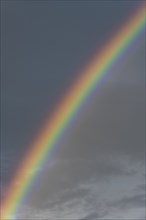 Rainbow in front of dark rain cloud, Germany, Europe