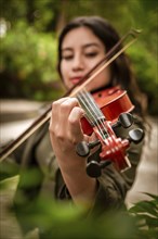 Lifestyle of girl with her violin playing a melody outdoors, Concept of smiling female violinist.