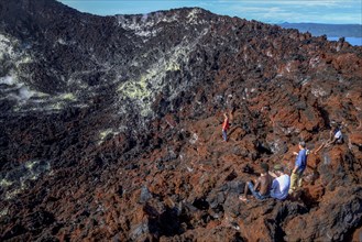 Hikers at the crater rim of the still active volcano Mount Tavurvur, Rabaul, East New Britain,