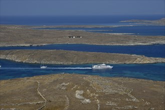 View over the island of Delos with an excursion boat, Cyclades, Greece, Europe