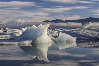 Ice floes, icebergs, reflection, mountains, clouds, sunny, Jökulsarlon, Iceland, Europe