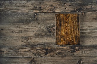 A rustic wooden surface features a detailed plank prominently placed in the center, showcasing