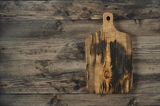 A beautifully crafted wooden cutting board is placed on a weathered wooden surface, showcasing its