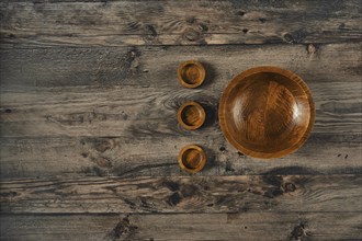 A collection of handcrafted wooden bowls is displayed on a rustic wooden surface, showcasing the