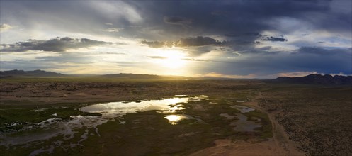 Aerial panorama of the sand dunes Elsen Tasarhai (Bayan Gobi) and lake at sunset in Mongolia