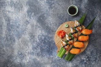 Sashimi sushi set on wooden board. Stone background. Top view