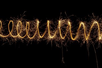 Spiral lights with sparks on a black background. Christmas lights on a long exposure