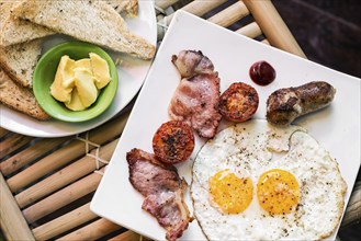 Traditional classic english british fried breakfast with eggs bacon tomato sausage and toast set