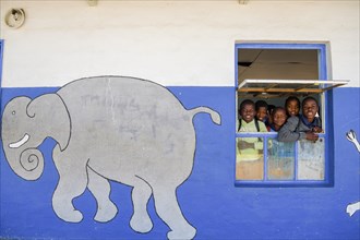 Children look out of the window of their classroom at Gariseb Primary School, boarding school for