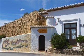 Small restaurant in a white building with painted walls and rustic charm under a blue sky, Pedro