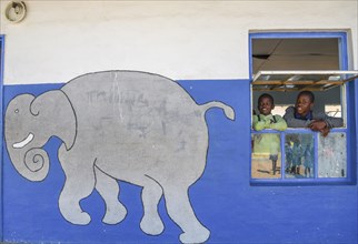 Children look out of the window of their classroom at Gariseb Primary School, boarding school for