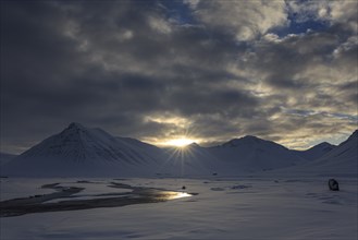 Sunrise over valley with river, sun star, clouds, snow, winter, mountains, Thingeyri, Westfjords,