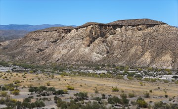 Rocky mountain landscape with scattered desert vegetation and a clear blue sky, Llano de Buho,