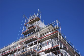 Scaffolding in front of a building under a clear blue sky, Fløibanen mountain station, Bergen,