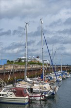 Sailing yachts in the north-east harbour, passenger ship MS Maud of Hurtigruten AS, offshore island