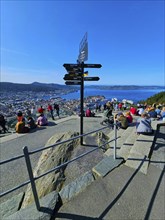 View of the city of Bergen with fjord, Bergen, signposts and a crowd of people admiring the