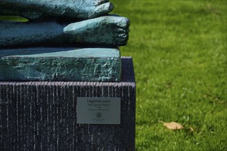 Feet of the Lying poet statue with inscription sign, Bergen, Vestland, Norway, Europe