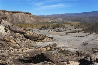 Gorge in a dry mountain landscape with rocks and a clear blue sky, Llano de Buho, Tabernas Desert,