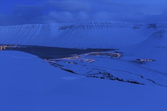 Fjord landscape at dusk, snow, illuminated city, mountains, Isafjördur, Westfjords, Iceland, Europe