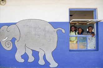 Children look out of the window of their classroom at Gariseb Primary School, boarding school for