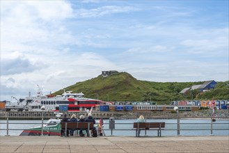 View over the jetty to the high-speed catamaran Halunder Jet, colourful lobster shacks, midland