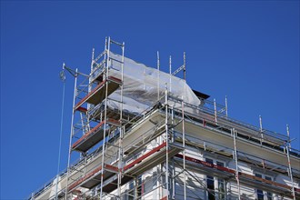 Scaffolding in front of a building under a clear blue sky, Fløibanen mountain station, Bergen,