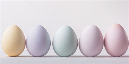 Row of pastel colored Easter eggs in front of white background with copy space. Generative Ai, AI