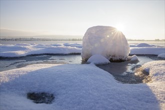 A snow-covered block of ice on a frozen body of water at sunrise, Seegarten, Allensbach, Lake