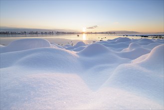 Winter lake at sunrise, many snow hills and icy atmosphere, Seegarten, Allensbach, Lake Constance,