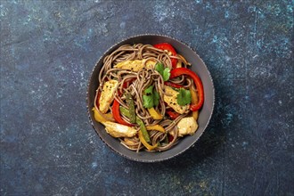 Japanese dish buckwheat soba noodles with chicken and vegetables carrot, bell pepper and green