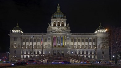 Illuminated facade of a grand neoclassical museum at night with bright lights enhancing its