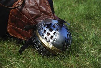 Iron helmet of knight on green grass