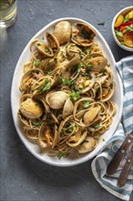 Seafood Pasta. ITALIAN SPAGHETTI ALLE VONGOLE. Clams spaghetti on white plate with white wine, gray