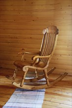 Carved wooden rocking-chair in the country-style interior