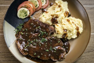 Beef steak meal with mashed potato and gravy sauce on table