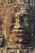 Giant stone face at Bayon Temple at sunset, Angkor Wat, Cambodia, Asia