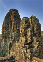 Giant stone faces at Bayon Temple at sunrise, Angkor Wat, Cambodia, Asia