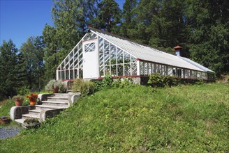 Large glass greenhouse on the green lawn