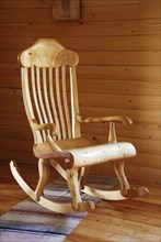 Carved wooden rocking-chair in the country-style interior