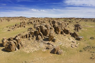 Aerial view at rock formations and stacked stones on granite hilltops. Baga Gazriin Chuluu, Gobi